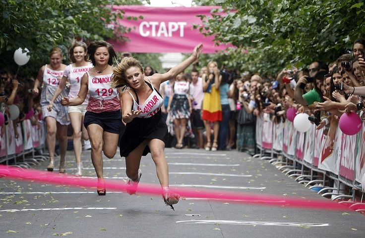 A young woman falls down as others run in Glamour high heels race in downtown Moscow, Russia, Saturday, July 7, 2012. Participants of the high heel run were challenged to race 50 meters in stilettos of at least 9 cm (2.54 inches). (AP Photo/Alexander Zemlianichenko Jr)